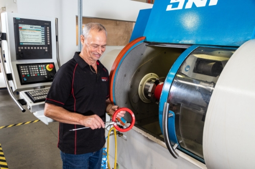 Industrial photographers sydney capturing a man in a factory measuring a seal.