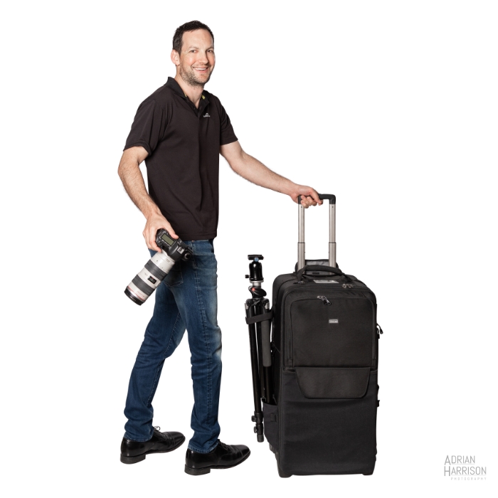 Newcastle professional product photographer Adrian Harrison. Holding camera bag, camera and tripod.