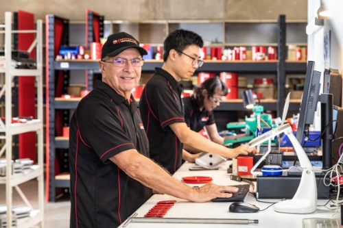Industrial portraits of staff in a factory in Sydney. Staff are standing at a benching working on a product.