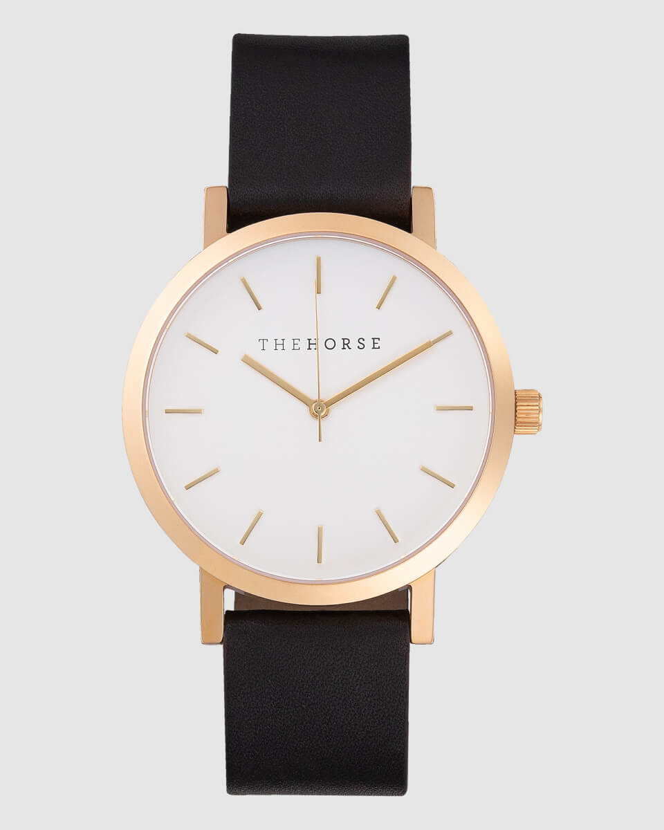 front view image of a gold watch with black strap