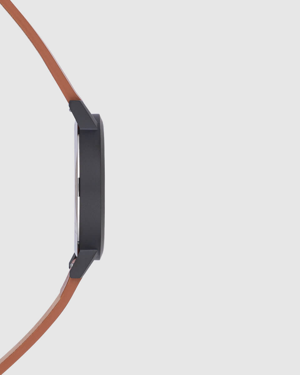 photo of a black watch with brown strap side view